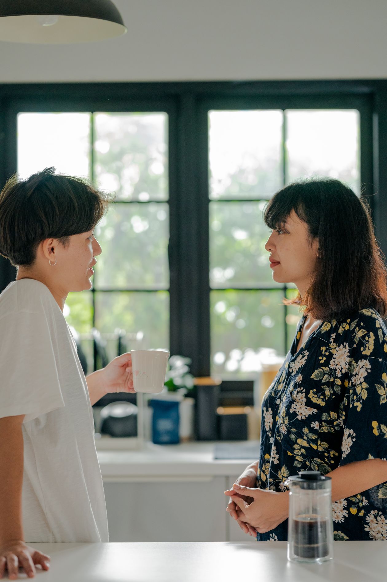 A couple sharing coffee and conversation in their kitchen